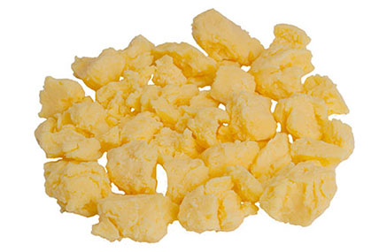 Fluffy precooked scrambled eggs served on a white plate