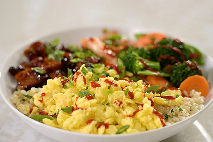 Korean style rice bowl topped with eggs, vegetables, and protein