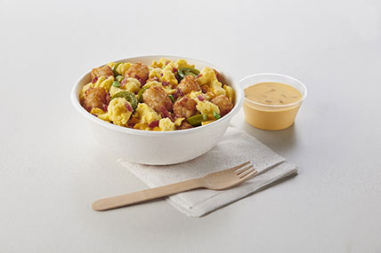 Breakfast scramble bowl with eggs, potatoes, vegetables, and cheese